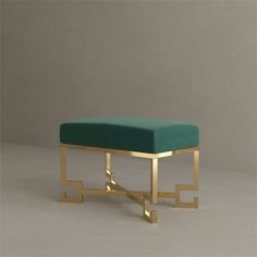 a gold and green ottoman sitting on top of a white floor next to a wall