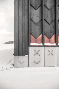 the side of a building with decorative designs on it's sides and snow covered ground