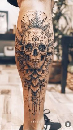 a woman's leg with a skull and flower tattoo on it