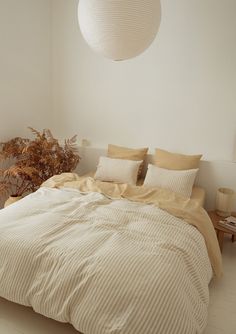 a large bed sitting next to a plant in a bedroom