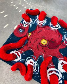 an octopus rug on the ground with red and blue carpeting in front of it