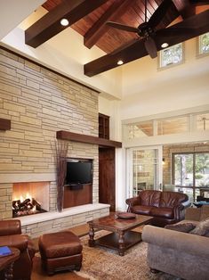 a living room filled with furniture and a flat screen tv mounted on the wall above a fireplace