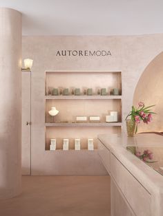 the inside of a store with shelves and flowers in vases next to candles on display