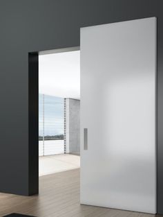 an open white door in a room with wooden floors and black walls on the wall