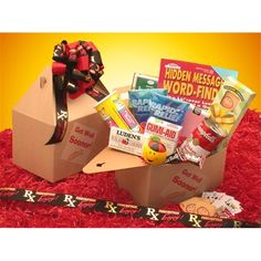 an open box filled with snacks on top of a red carpet next to a ribbon