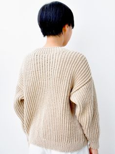 the back of a woman's sweater that is open to reveal an oversized, ribbed design