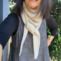 an older woman with glasses and a scarf around her neck is smiling at the camera