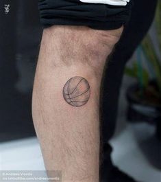 a man's leg with a basketball tattoo on his left arm and the ball in the center