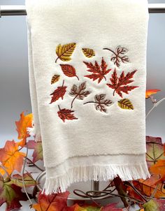 a towel hanging on a rack with autumn leaves