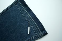 a pen sticking out of the back pocket of a pair of blue jean pants with white stitching