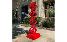 a red sculpture sitting in front of a building