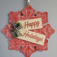 a wooden sign with the words happy holidays on it hanging from a wall ornament