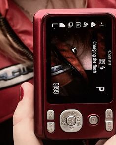 a person holding up a red cell phone with an image on the front and side