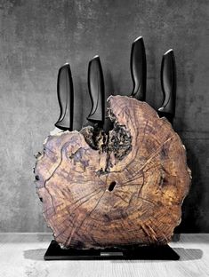 a group of knives sitting on top of a piece of wood