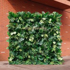 a wall covered in green leaves with the words boss marriage written on it's side