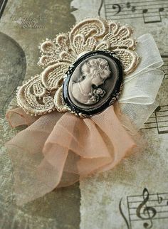 a brooch with an image of a woman's head on it and music notes in the background