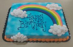 a birthday cake with clouds and a rainbow on it