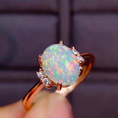 An Elegant and Romantic Ethiopian Opal Ring featuring a shimmering, iridescent opal 8x6 mm accented by sparkling brilliant round diamonds. The ring is handcrafted from 14K Rose gold. As an engagement ring, opals are a perfect representation of the unique spark and fire of your relationship, and their non-replicable nature is a huge draw for those that want a truly one-of-a-kind ring,Custom Order:This Ring is offered in different sizes, gold color and the central stone can be upgraded/downgraded Gold Opal Engagement Ring, Opal Promise Ring, Montana Sapphire Engagement Ring, Sapphire Engagement Ring Set, Sun And Moon Necklace, Australian Opal Ring, Green Sapphire Engagement, Green Sapphire Engagement Ring, Victorian Ring