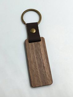 a wooden keychain with a metal ring hanging from it's side on a white surface