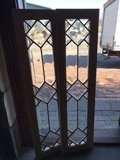 an open glass door on the side of a building with a truck in the background