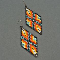 two pairs of beaded earrings with orange and blue designs on the front, one is shaped like a fish