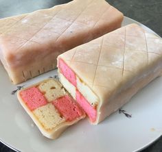 two pieces of cake on a plate with one slice cut out and the other half eaten