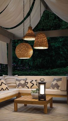 a living room with couches and lamps hanging from the ceiling