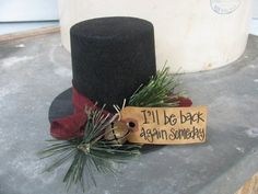 a black top hat with a sign that says i'll be back again somewhere