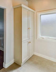 an empty room with cabinets and a window