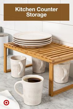 the kitchen counter is set up with cups and plates