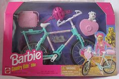 the barbie bike has pink accessories on it's handlebars and is in its original box