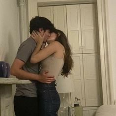 a man and woman kissing in the kitchen