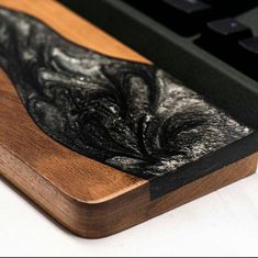 a close up of a wood and metal object on a table next to a keyboard