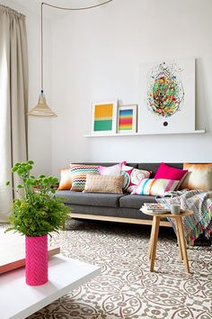 a living room filled with furniture and a potted plant on top of a table