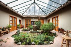 the inside of a house with lots of plants and potted plants on the ground