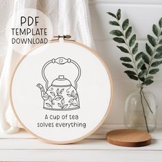 a cup of tea solves everything embroidery pattern on a white table with a pot and green plant