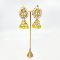 Introduce traditional charm to any event with Savina Jhumka Earrings. These yellow earrings are lightweight and comfortable, making them perfect for mehndi, sangeet, or garba. Adorned with pearls, these jhumkas are a must-have for any jewelry collection. Add a touch of elegance and tradition to your wardrobe with Savina Jhumka Earrings! Festive Kundan Beaded Earrings With Latkans, Festive Bollywood Kundan Beaded Earrings, Chandbali Beaded Earrings For Diwali, Festive Chandbali Beaded Earrings For Diwali, Festive Chandbali Meenakari Beaded Earrings, Festival Meenakari Chandbali Beaded Earrings, Festive Meenakari Beaded Earrings For Wedding, Chandbali Beaded Earrings For Party And Festivals, Bollywood Kundan Beaded Earrings For Festivals