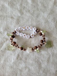 a bracelet with words and charms on it sitting on a white cloth covered tablecloth