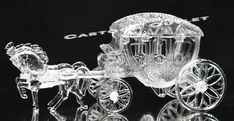 a clear glass horse drawn carriage on a black background with the word cart't est written above it