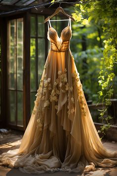 a dress hanging on a clothes rack in front of a window with greenery behind it