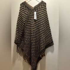 Pretty 100% Acrylic Poncho, Cozy And Warm For Those Chilly Fall Days Ahead. . One Size Fits All. Poncho Measures Approximately 39” In Length. Color Is Beige/Black. Smoke Free Home. Cozy Brown Shawl For Fall, Brown One Size Poncho With Fringe, One Size Brown Fringe Poncho, Brown Fringe One Size Poncho, One Size Brown Cape For Fall, One-size Brown Cape For Fall, Cozy Black Cape Poncho, Brown Fringed Poncho For Fall, Brown Fringe Poncho For Fall