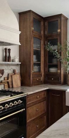 a kitchen with an oven, cabinets and counter tops in brown wood tones is shown