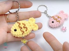 two crocheted keychains in the shape of animals are being held by someone's hand