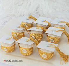 graduation caps and tassels are on a white platter with gold foiling