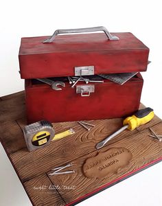 a cake made to look like a toolbox and tools on a wooden table top