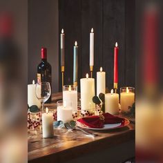 a table topped with candles and wine bottles