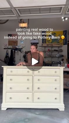 a woman sitting on top of a dresser next to a white wall with words above it