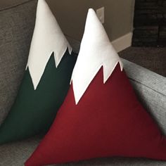 two christmas pillows sitting on top of a couch