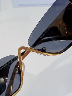 a pair of black and gold sunglasses sitting on top of a table