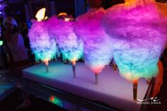 colorful cotton candy lollipops sitting on top of a white tray at a party